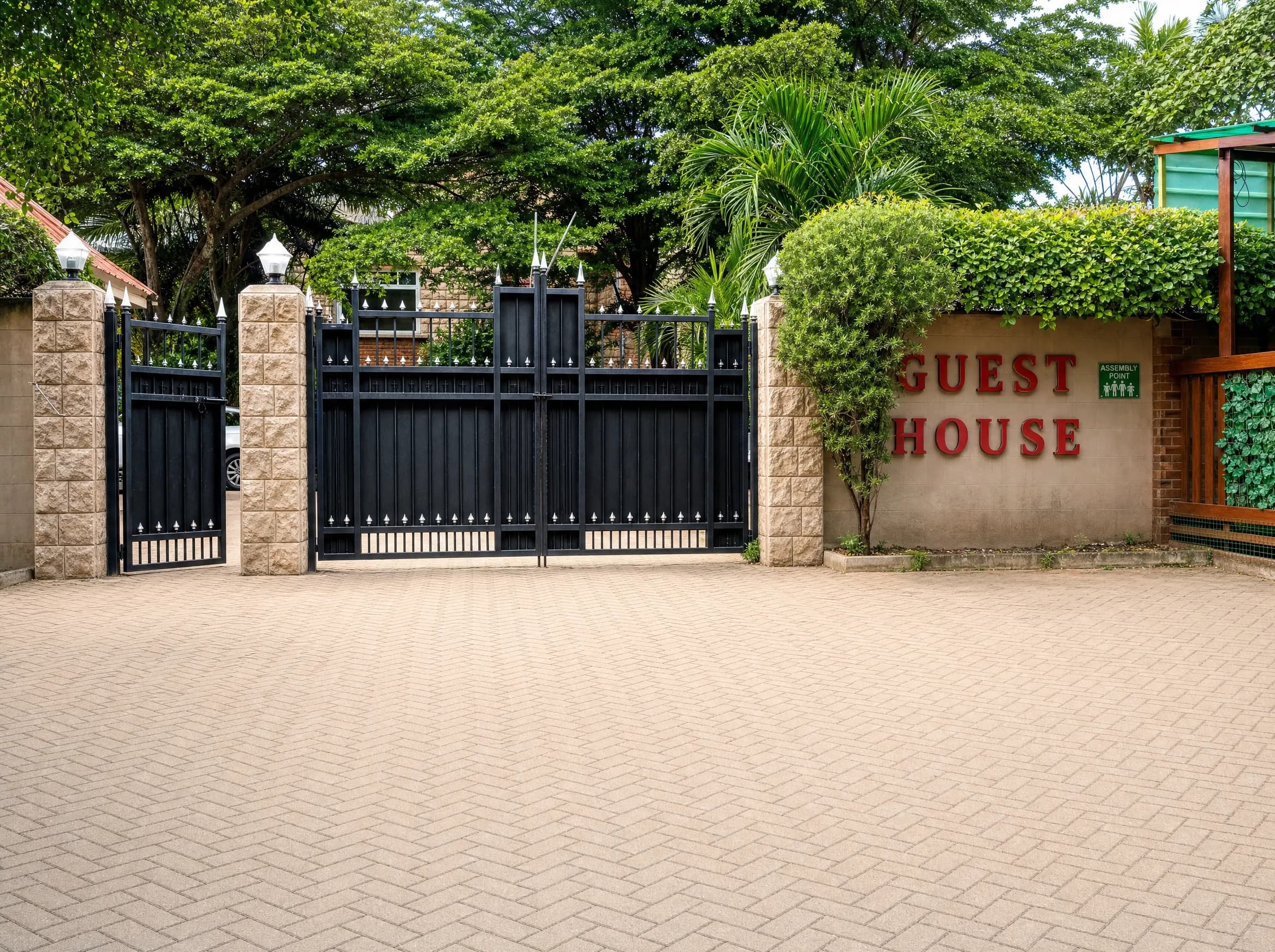 The black gate at the entrance to Calabash Green, under mature trees